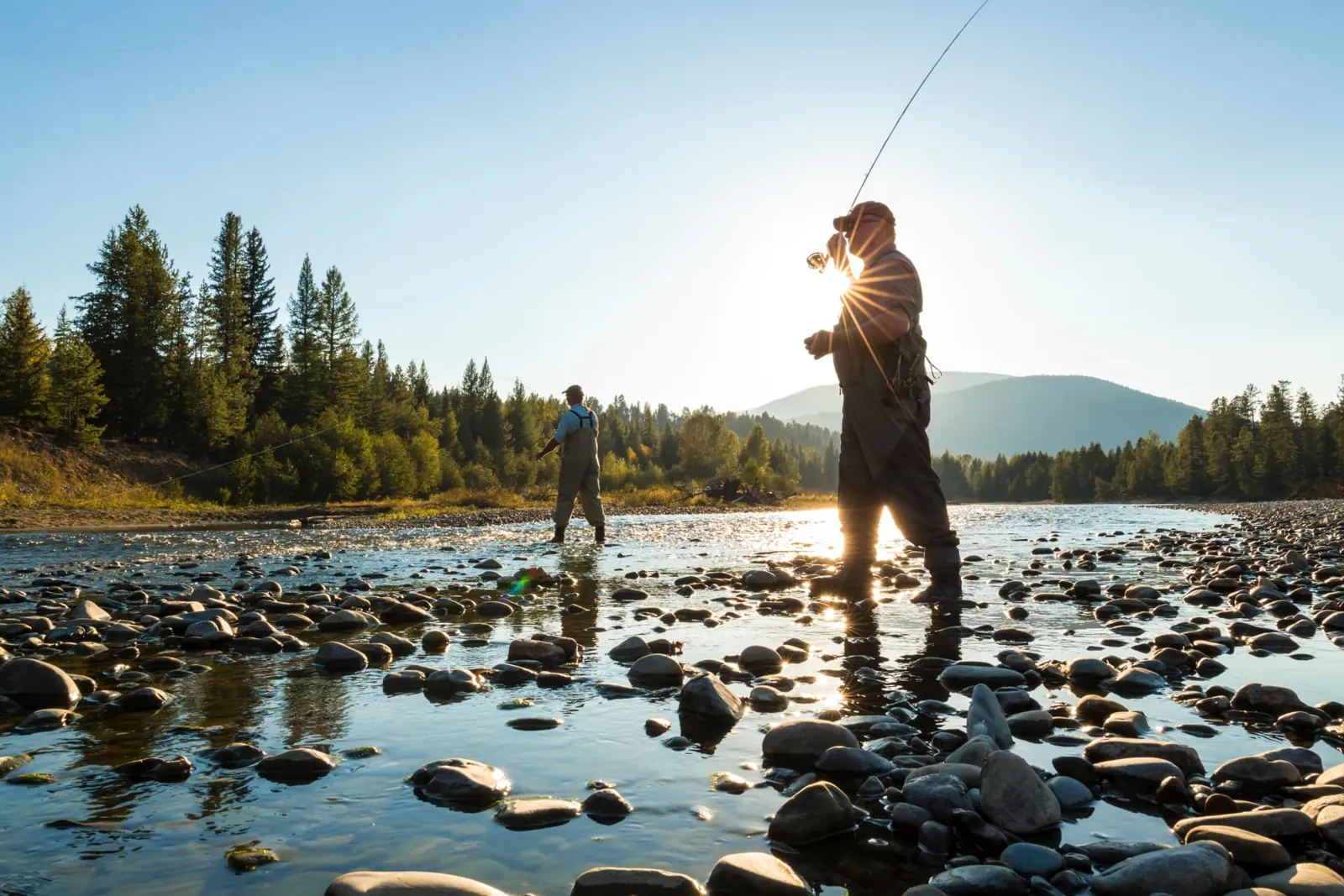 Two anglers fly fishing a rocky mountain river