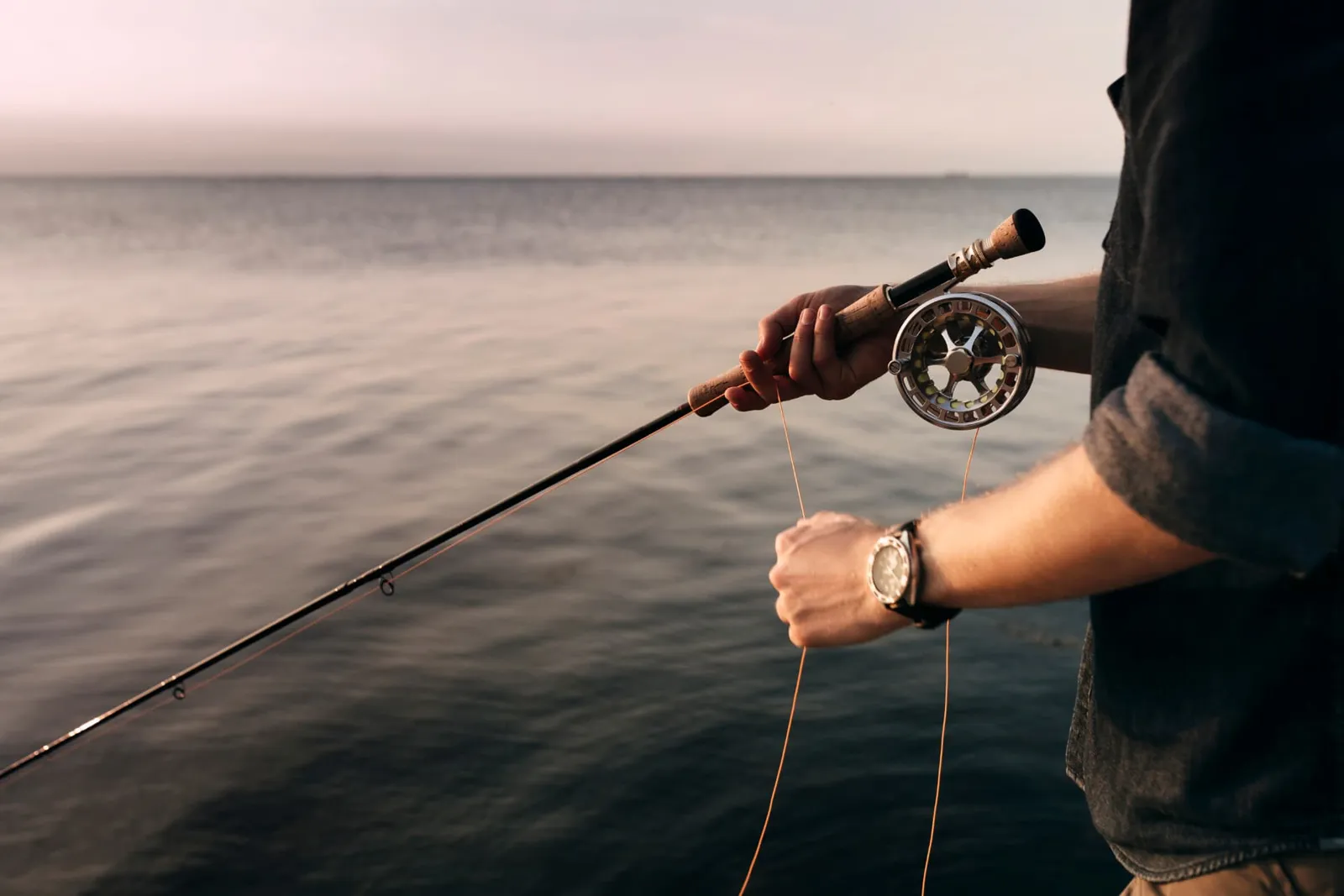 Close-up of a fly reel and line over calm water